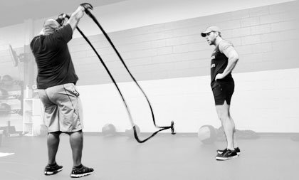 One-on-one personal training session with student squating while instructor directs.