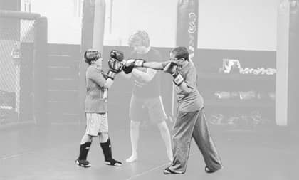 Two youth getting a boxing lesson by a Coach