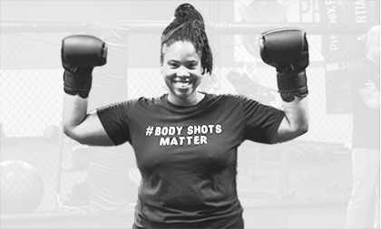 Woman punching a pad that the coach is holding